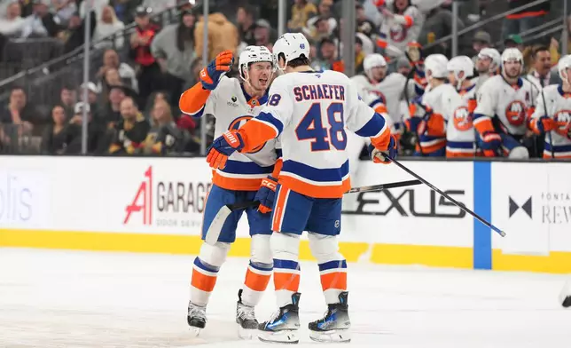 New York Islanders center Mathew Barzal (13) celebrates his goal with defenseman Matthew Schaefer (48) against the Vegas Golden Knights in the third period of an NHL hockey game Thursday, Nov. 13, 2025, in Las Vegas. (AP Photo/Candice Ward)