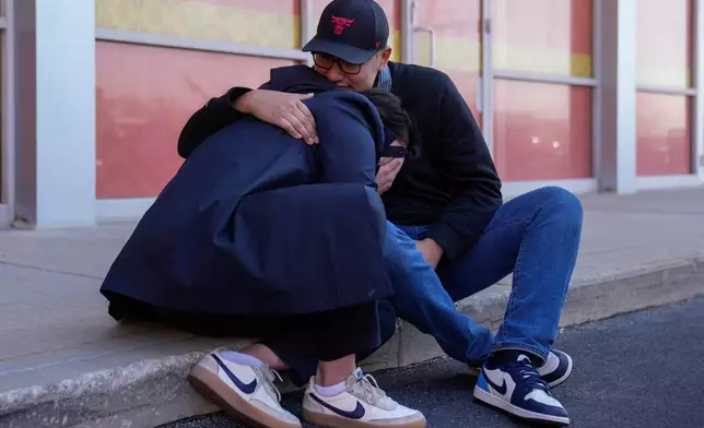 Maria Guzman, left, and Sergio Rocha, parents of young children, comfort each other outside of Rayito de Sol Spanish Immersion Early Learning Center after federal immigration agents took a daycare teacher Wednesday, Nov. 5, 2025, in Chicago. (AP Photo/Erin Hooley)