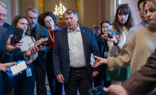 Sen. Mike Rounds, R-S.D., a member of the Senate Appropriations Committee, is surrounded by congressional reporters looking for updates on a plan to end the 38 day government shutdown, at the Capitol in Washington, Friday, Nov. 7, 2025. (AP Photo/J. Scott Applewhite)