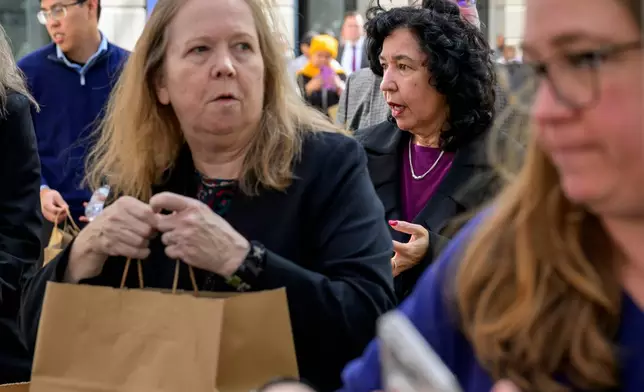 People receive free meals from the World Central Kitchen as they provide food to federal employees and their families near the U.S. Navy Memorial Plaza, during the federal government shutdown, Wednesday, Nov. 5, 2025, in Washington. (AP Photo/Rod Lamkey, Jr.)