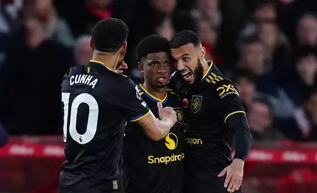 Manchester United's Amad Diallo, center, celebrates scoring with teammates Matheus Cunha, left, and Noussair Mazraoui during the English Premier League match between Nottingham Forest and Manchester United in Nottingham, England, Saturday Nov. 1, 2025. (Bradley Collyer/PA via AP)