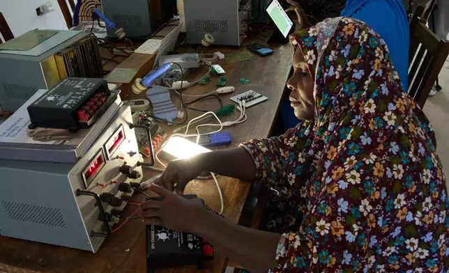 A "Solar Mama" technician wires up a solar charge controller at the campus of Barefoot College International in Kinyasini, Unguja, Zanzibar, July 23, 2025. (AP Photo/Jack Denton)