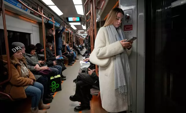 FILE - A woman looks at her smartphone on the subway in Moscow, Russia, March 4, 2025. (AP Photo/Alexander Zemlianichenko, File)