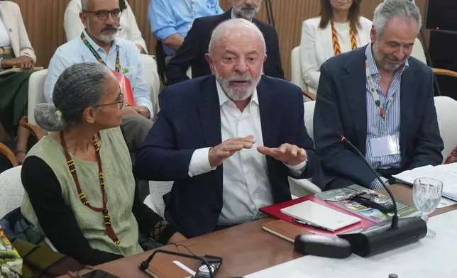 Brazil President Luiz Inacio Lula da Silva, center, gestures as he speaks with Indigenous groups next to André Corrêa do Lago, COP30 president, right, and Marina Silva, Brazil environment minister, at the COP30 U.N. Climate Summit, Wednesday, Nov. 19, 2025, in Belem, Brazil. (AP Photo/Andre Penner)