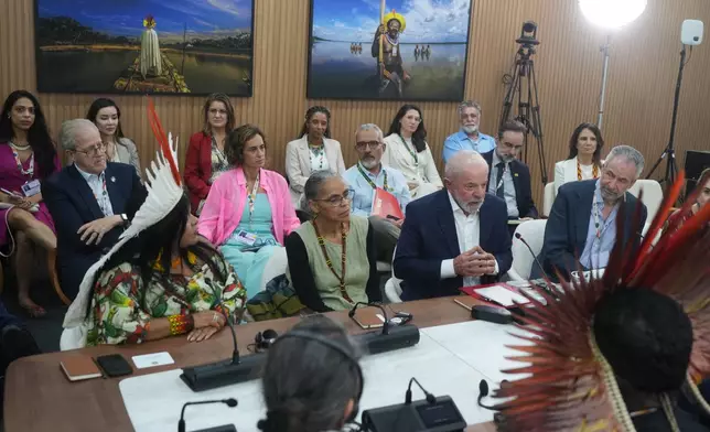 Brazil President Luiz Inacio Lula da Silva, second from right, sits with Brazil Indigenous Peoples Minister Sonia Guajajara, left, Marina Silva, Brazil environment minister, second from left, and André Corrêa do Lago, COP30 president, right, as they speak with members from Indigenous groups at the COP30 U.N. Climate Summit, Wednesday, Nov. 19, 2025, in Belem, Brazil. (AP Photo/Andre Penner)
