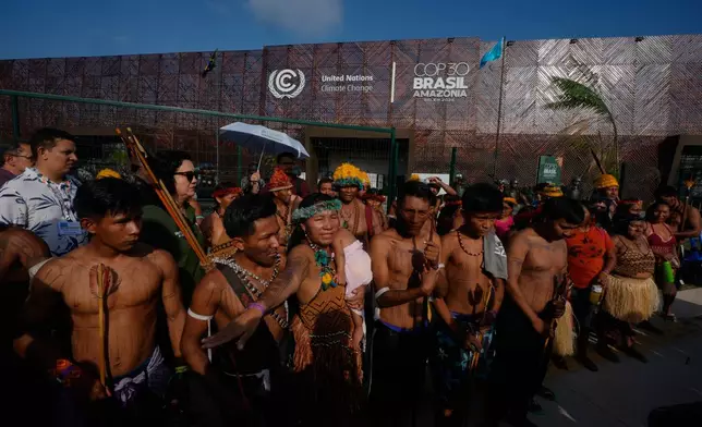 An Indigenous group blocks an entrance to the COP30 U.N. Climate Summit, Friday, Nov. 14, 2025, in Belem, Brazil. (AP Photo/Fernando Llano)