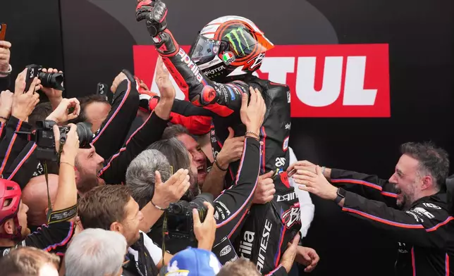 Italian rider Marco Bezzecchi of the Aprilia Racing celebrates after winning the Valencia Motorcycle MotoGP Grand Prix at the Ricardo Tormo circuit in Cheste, near Valencia, Spain, Sunday, Nov. 16, 2025. (AP Photo/Alberto Saiz)