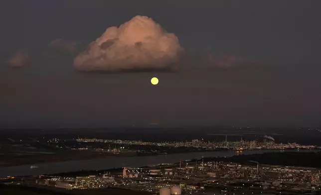 In this aerial photo, a supermoon rises above the Dow Chemical Plant and the Shell Norco Oil Refinery along the Mississippi River in St. John the Baptist Parish, La., Wednesday, Nov. 5, 2025. (AP Photo/Gerald Herbert)