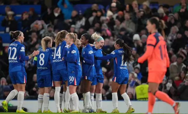 Chelsea's Ellie Carpenter, 2nd right, celebrates after scoring the opening goal during the women's Champions League opening phase soccer match between Chelsea FC and FC Barcelona, in London, Thursday, Nov. 20, 2025. (AP Photo/Kin Cheung)