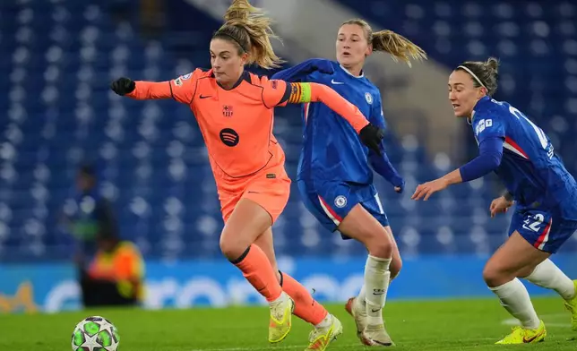 Barcelona's Alexia Putellas runs with the ball away from Chelsea's Wieke Kaptein and Lucy Bronze, right, during the women's Champions League opening phase soccer match between Chelsea FC and FC Barcelona, in London, Thursday, Nov. 20, 2025. (AP Photo/Kin Cheung)