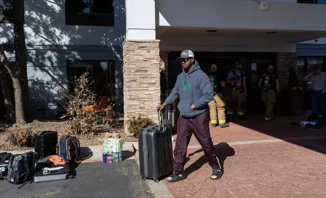 Michael Johnson of Nacogdoches, Texas gathers his belongings from the Holiday Inn Express on Thursday, Nov. 13, 2025 after he was able to return due to evacuation orders following an ammonia gas leak at the hotel in Weatherford, Okla. the previous night. (AP Photo/Alonzo Adams)
