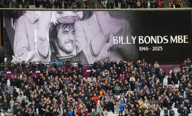 A giant screen displays a Wast Ham legend Billy Bonds died aged 79 prior to the start of the English Premier League soccer match between West Ham United and Liverpool, in London, Sunday, Nov. 30, 2025. (AP Photo/Kirsty Wigglesworth)