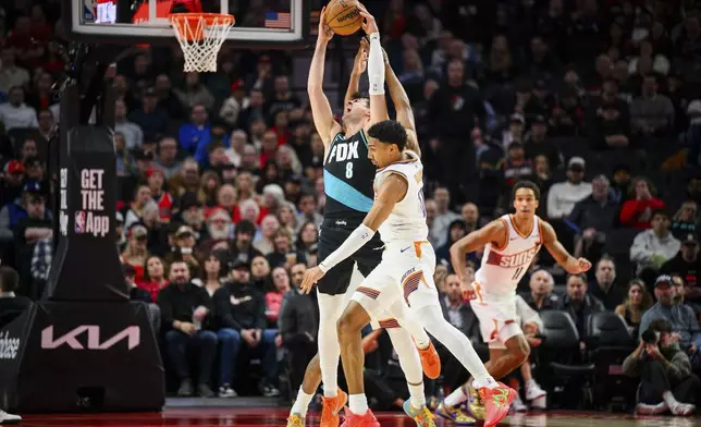 Portland Trail Blazers forward Deni Avdija (8) and Phoenix Suns forward Ryan Dunn (0) battle for a loose ball during the first half of an NBA basketball game on Tuesday, Nov. 18, 2025, in Portland, Ore. (AP Photo/Molly J. Smith)