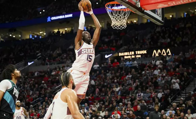 Phoenix Suns center Mark Williams (15) dunks the ball during the first half of an NBA basketball game against the Portland Trail Blazers on Tuesday, Nov. 18, 2025, in Portland, Ore. (AP Photo/Molly J. Smith)