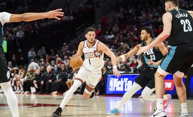 Phoenix Suns guard Devin Booker (1) drives down the court during the first half of an NBA basketball game against the Portland Trail Blazers on Tuesday, Nov. 18, 2025, in Portland, Ore. (AP Photo/Molly J. Smith)