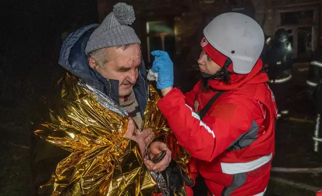 A paramedic gives first aid to a resident who was injured in a Russian airstrike in Kharkiv, Ukraine, late Sunday, Nov. 23, 2025. (AP Photo/Andrii Marienko)
