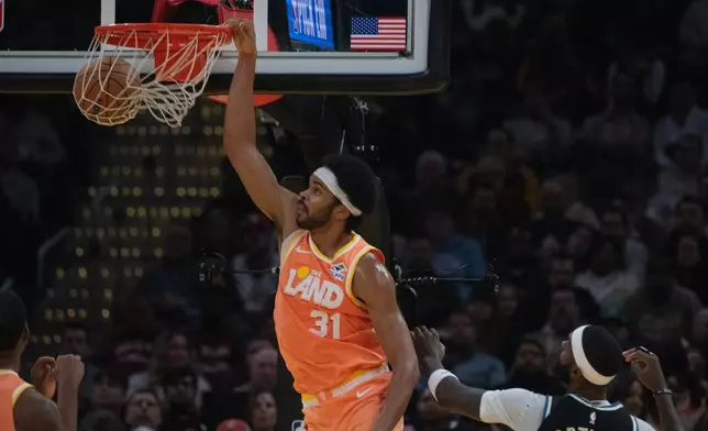 Cleveland Cavaliers' Jarrett Allen dunks as Milwaukee Bucks' Bobby Portis Jr. looks on during the first half of an NBA basketball game in Cleveland, Monday, Nov. 17, 2025. (AP Photo/Phil Long)