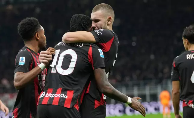 AC Milan's Strahinja Pavlovic, centre right, celebrates with Rafael Leao, centre left, after scoring the opening goal during the Serie A soccer match between AC Milan and Roma in Milan, Italy, Sunday, Nov. 2, 2025. (AP Photo/Antonio Calanni)