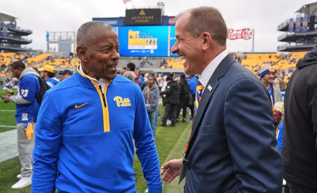 ACC Commissioner Jim Phillips, right, visits with Hall of Fame running back Tony Dorsett before an NCAA college football game between Pittsburgh and Notre Dame in Pittsburgh, Nov. 15, 2025. (AP Photo/Gene J. Puskar)