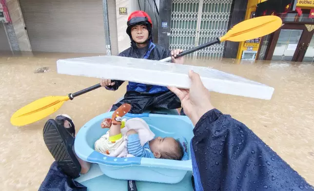 A baby is evacuated from flood in Khanh Hoa, Vietnam Thursday, Nov. 20, 2025. (Nguyen Huy Thanh/VNA via AP)