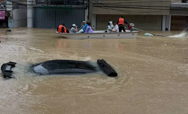 Thai rescue crew on boat move past a car submerged in floodwaters in Songkhla province, southern Thailand, Monday, Nov. 24, 2025. (AP Photo)