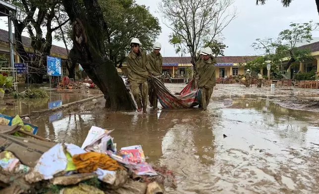 People clean up after flood recedes in Dak Lak, Vietnam Monday, Nov. 24, 2025. (Nguyen Dung/VNA via AP)