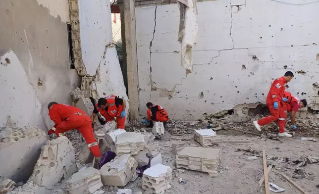 Palestinian rescue workers collect body remains at the scene where an Israeli strike on Tuesday night hit the Ein el-Hilweh Palestinian refugee camp, in the southern port city of Sidon, Lebanon, Wednesday, Nov. 19, 2025. (AP Photo/Mohammed Zaatari)