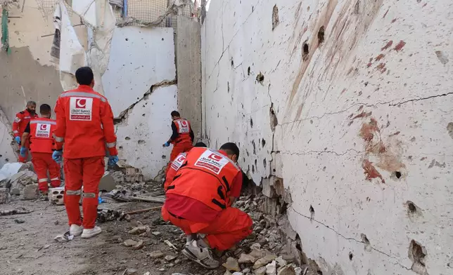 Palestinian rescue workers collect body remains at the scene where an Israeli strike on Tuesday night hit the Ein el-Hilweh Palestinian refugee camp, in the southern port city of Sidon, Lebanon, Wednesday, Nov. 19, 2025. (AP Photo/Mohammed Zaatari)