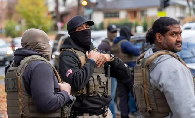 Federal law enforcement officers with Immigration and Customs Enforcement (ICE) and Enforcement and Removal Operations (ERO) conduct a traffic stop and detain people, Monday, Nov. 17, 2025, in Washington. (AP Photo/Alex Brandon)