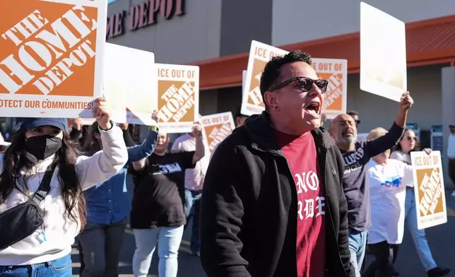 Organizing director for the National Day Laborer Organizing Network Jorge Torres, center, marches alongside protestors outside of a Home Depot, Wednesday, Nov. 19, 2025, in Charlotte, N.C. (AP Photo/Matt Kelley)