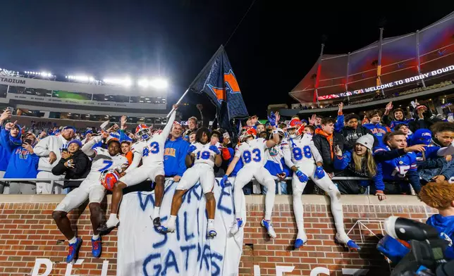 FILE -Florida players and fans celebrate after defeating Florida State in an NCAA college football game, Nov. 30, 2024, in Tallahassee, Fla. (AP Photo/Colin Hackley, File)