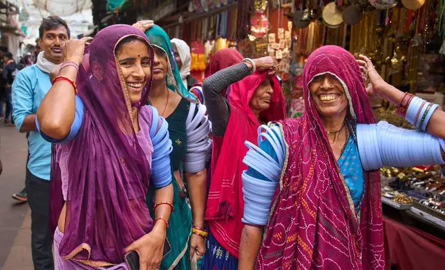 Women shop at a market near the annual cattle fair in Pushkar, in the western Indian state of Rajasthan, Monday, Oct. 27, 2025. (AP Photo/Rajesh Kumar Singh)