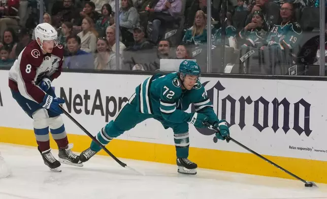 San Jose Sharks left wing William Eklund (72) reaches for the puck in front of Colorado Avalanche defenseman Cale Makar (8) during the first period of an NHL hockey game in San Jose, Calif., Saturday, Nov. 1, 2025. (AP Photo/Jeff Chiu)