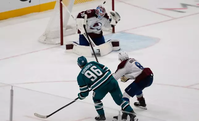 San Jose Sharks center Philipp Kurashev (96) watches his shot score past Colorado Avalanche goaltender Mackenzie Blackwood (39) and defenseman Cale Makar (8) during overtime of an NHL hockey game in San Jose, Calif., Saturday, Nov. 1, 2025. (AP Photo/Jeff Chiu)