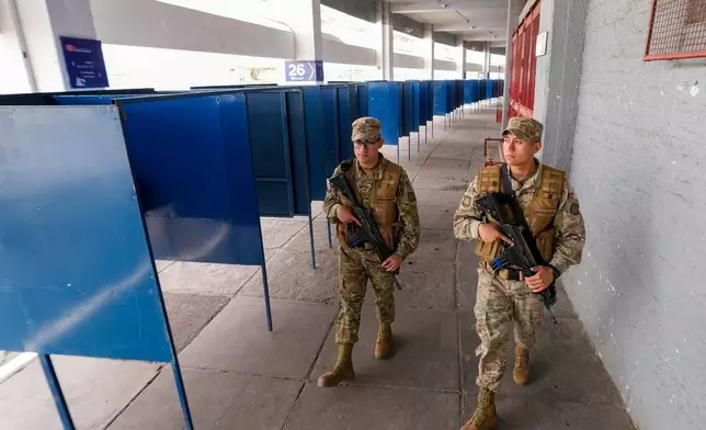 Soldiers patrol the National Stadium, which will be used as a polling station during Sunday's general elections, in Santiago, Chile, Saturday, Nov. 15, 2025. (AP Photo/Esteban Felix)