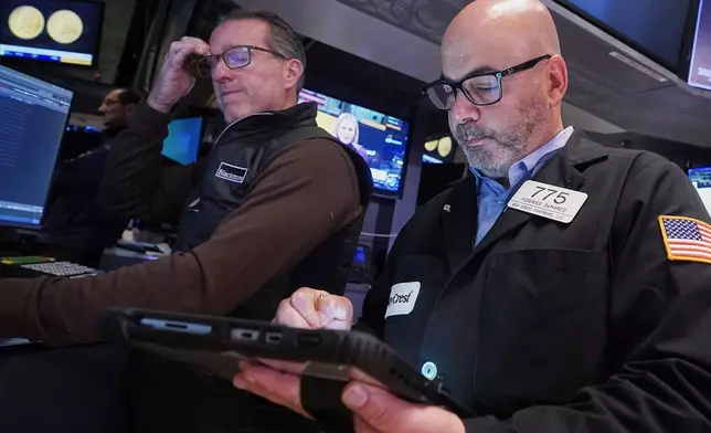 Specialist Glenn Carell, left, and trader Fred Demarco work on the floor of the New York Stock Exchange, Tuesday, Nov. 18, 2025. (AP Photo/Richard Drew)