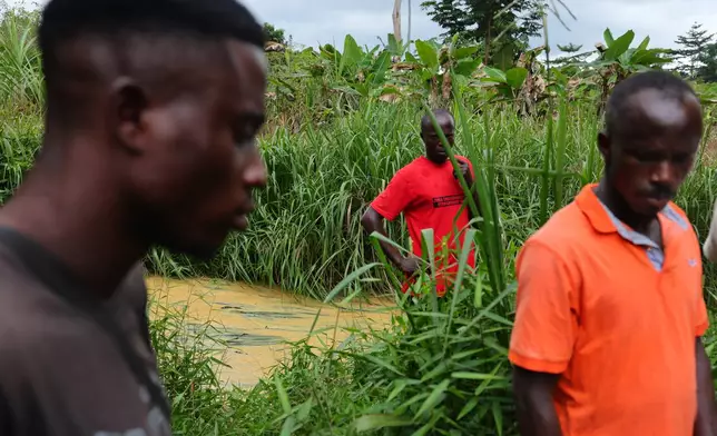 Members of a local anti-illegal gold mining task force patrol a river polluted by illegal gold mining in the Jema community of the Western North Region, Ghana, Thursday, Sept. 11, 2025. (AP Photo/Tsraha Yaw)