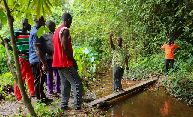 Friar Joseph Kwame Blay, center, a Ghanaian Franciscan Catholic Pries and native of Jema, and members of a local anti-illegal gold mining task force patrol a forest reserve in the Jema community in the Western North Region, Ghana, Thursday, Sept. 11, 2025. (AP Photo/Tsraha Yaw)
