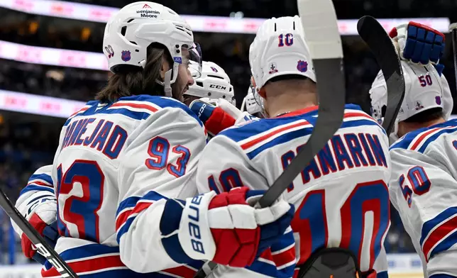 New York Rangers center Mika Zibanejad (93), left wing Artemi Panarin (10) celebrate Will Cuylle's goal during the first period of an NHL hockey game against the Tampa Bay Lightning, Wednesday, Nov. 12, 2025, in Tampa, Fla. (AP Photo/Jason Behnken)