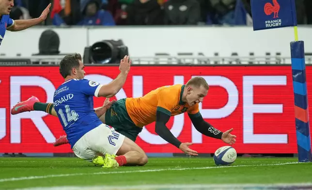 Australia's Max Jorgensen, right, pounces on the ball to score a try during the rugby union Nations Series match between France and Australia in Saint-Denis, outside Paris, Saturday, Nov. 22, 2025. (AP Photo/Christophe Ena)