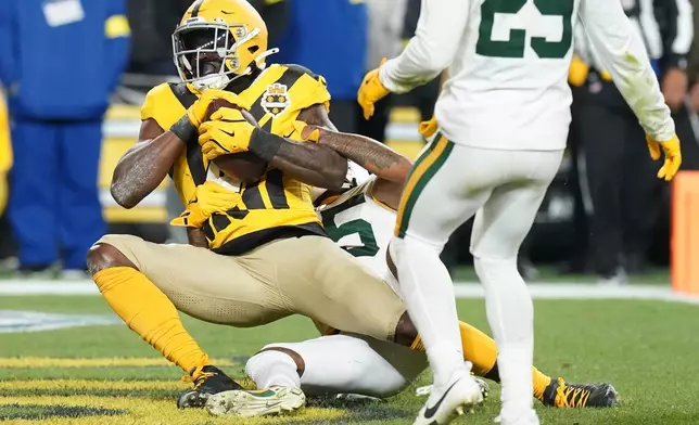 Pittsburgh Steelers' DK Metcalf catches a touchdpwn pass with Green Bay Packers' Keisean Nixon defending during the first half of an NFL football game Sunday, Oct. 26, 2025, in Pittsburgh. (AP Photo/Matt Freed)