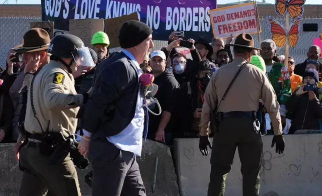 Cook County Sheriff Police guard as Illinois State police detain a protester outside an ICE processing facility in the Chicago suburb of Broadview, Ill., Friday, Nov. 14, 2025. (AP Photo/Nam Y. Huh)