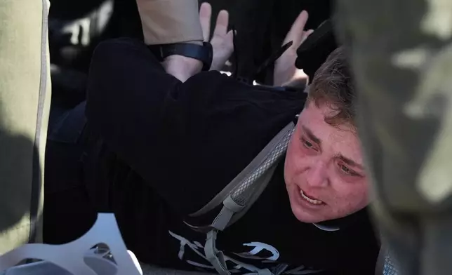 Illinois State police detain a protester outside an ICE processing facility in the Chicago suburb of Broadview, Ill., Friday, Nov. 14, 2025. (AP Photo/Nam Y. Huh)