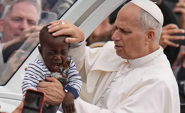 FILE - Pope Leo XIV blesses a child at the end of a Mass for the Jubilee of Migrants and Missionaries in St. Peter's Square at the Vatican, Oct. 5, 2025. (AP Photo/Alessandra Tarantino, File)