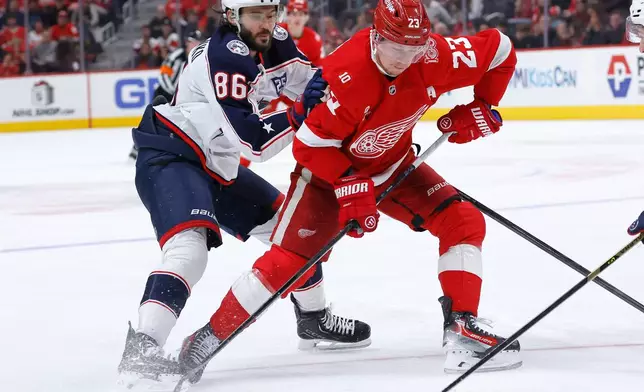 Detroit Red Wings left wing Lucas Raymond (23) drives on the goal past Columbus Blue Jackets right wing Kirill Marchenko (86) during the first period of an NHL hockey game Saturday, Nov. 22, 2025, in Detroit. (AP Photo/Duane Burleson)