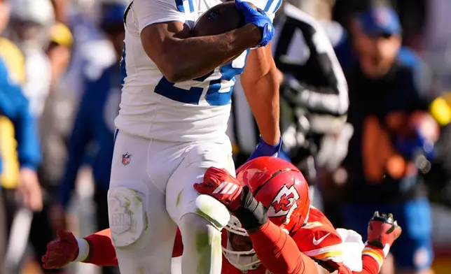 Indianapolis Colts running back Jonathan Taylor (28) is tackled by Kansas City Chiefs safety Bryan Cook (6) after picking up a first down during the second half of an NFL football game Sunday, Nov. 23, 2025, in Kansas City, Mo. (AP Photo/Charlie Riedel)