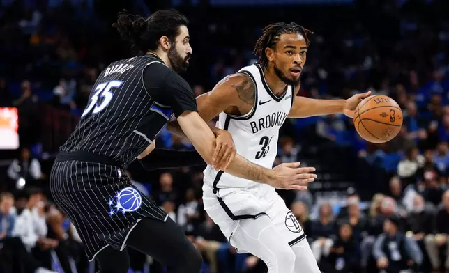 Orlando Magic center Goga Bitadze (35) defends Brooklyn Nets center Nic Claxton (33) during the first half of an NBA Cup basketball game, Friday, Nov. 14, 2025, in Orlando, Fla. (AP Photo/Kevin Kolczynski)