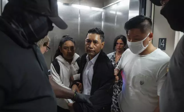 Immigration and Customs Enforcement agents pull a man out of an elevator as he and his daughter attempt to leave following a hearing in immigration court, Friday, Sept. 5, 2025, in New York. (AP Photo/Olga Fedorova)