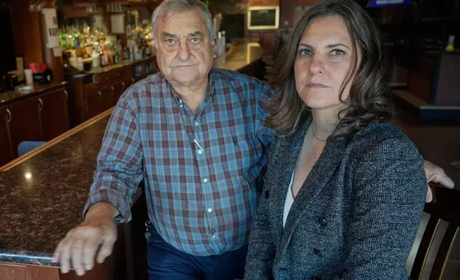 Tania Nemer, right, poses for a portrait with her father, Manuel Nemer, inside his business, Manny's Pub, Thursday, Oct. 9, 2025, in Akron, Ohio. (AP Photo/Sue Ogrocki)