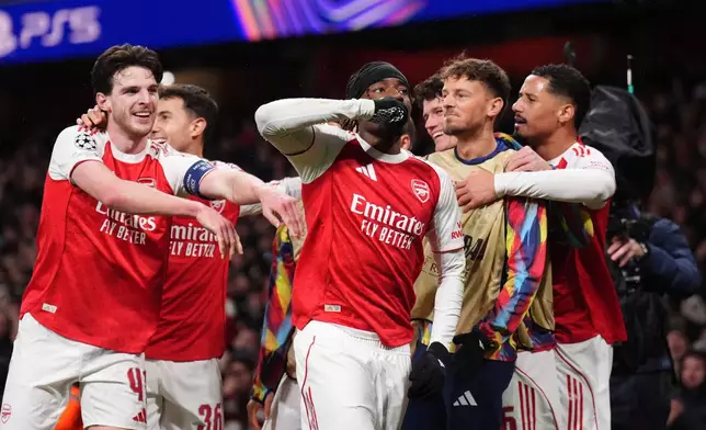 Arsenal's Noni Noni Madueke, center, celebrates after scoring his side's second goal during the Champions League opening phase soccer match between Arsenal and Bayern Munich in London, Wednesday, Nov. 26, 2025. (John Walton/PA via AP)